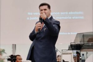 Pastor Edir Vinagre pregando em púlpito, apontando durante ministração com microfone.
