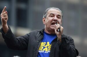 Pastor Silas Malafaia discursando em evento público, segurando microfone e gesticulando com o dedo apontado.