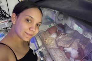 Vitória Souza registra momento ao lado do filho recém-nascido em incubadora hospitalar.