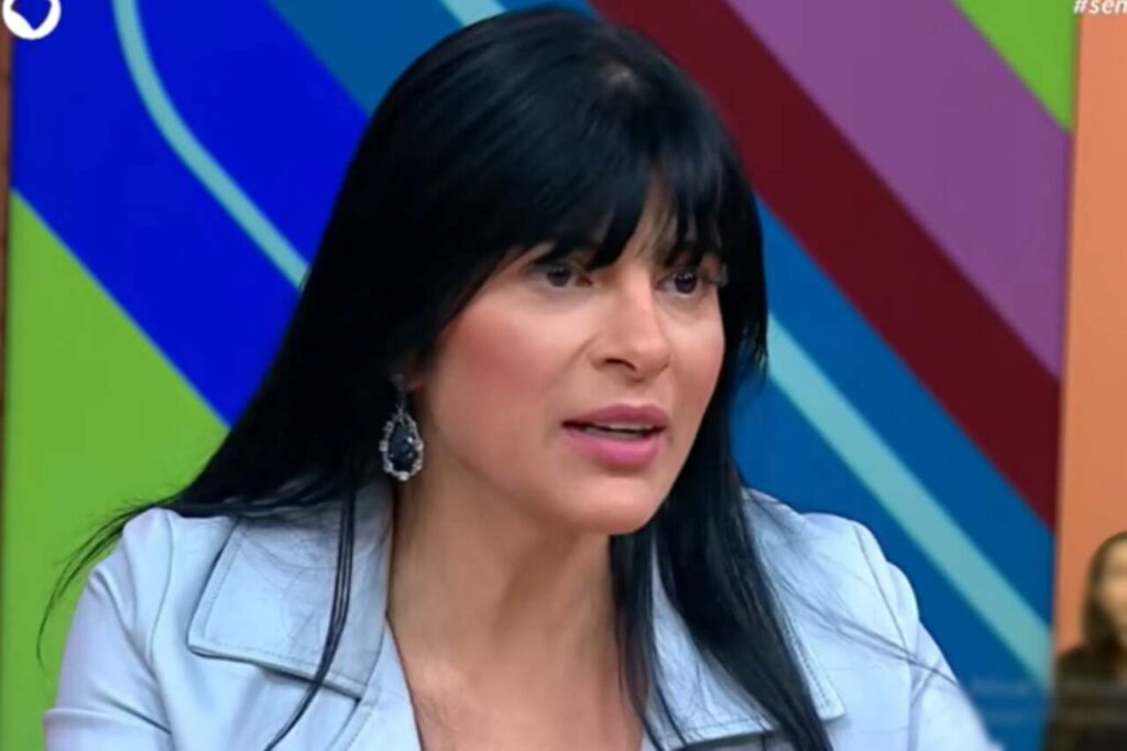 Fernanda Brum participa de programa de televisão enquanto fala durante entrevista em estúdio.