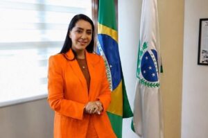 Mara Lima posa em gabinete ao lado das bandeiras do Brasil e do Paraná.