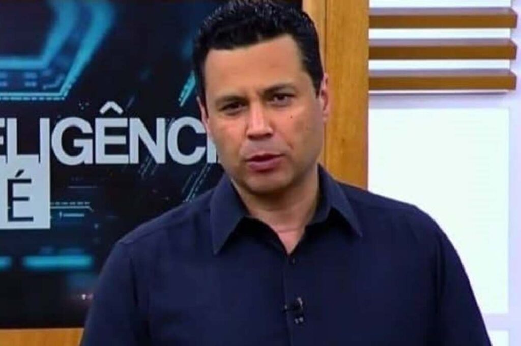 Bispo Renato Cardoso aparece em estúdio de televisão durante participação em programa, diante de um painel com temática de inteligência artificial.