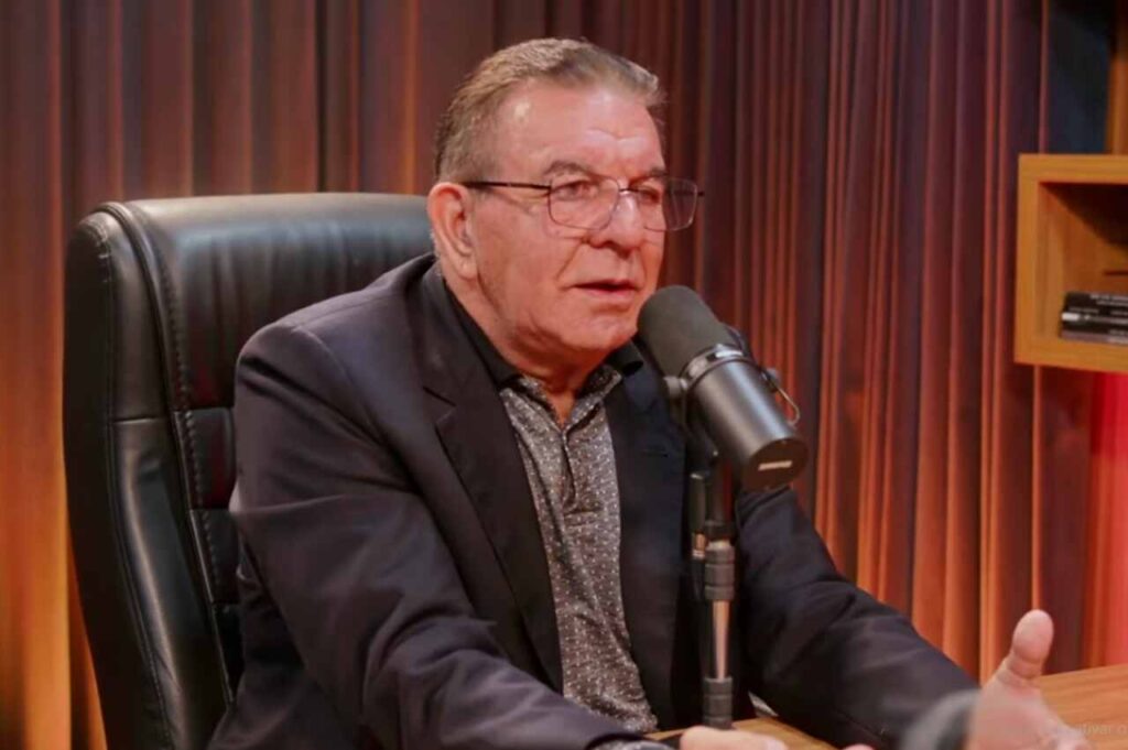 Pastor Jabes de Alencar participa de uma entrevista em podcast, sentado diante de um microfone em estúdio.