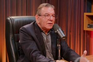 Pastor Jabes de Alencar participa de uma entrevista em podcast, sentado diante de um microfone em estúdio.
