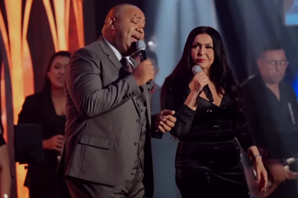 Os cantores gospel Gerson Rufino e Shirley Carvalhaes cantam juntos durante uma apresentação em um evento de música cristã.
