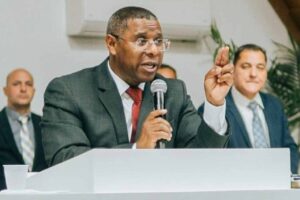 O pastor Osiel Gomes ministra durante culto, falando ao microfone diante da igreja.