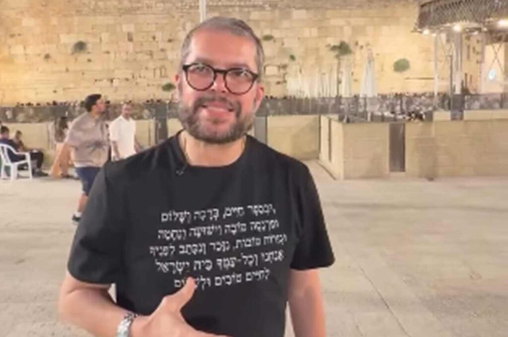 Agenor Duque de óculos aparece em frente ao Muro das Lamentações, em Jerusalém.