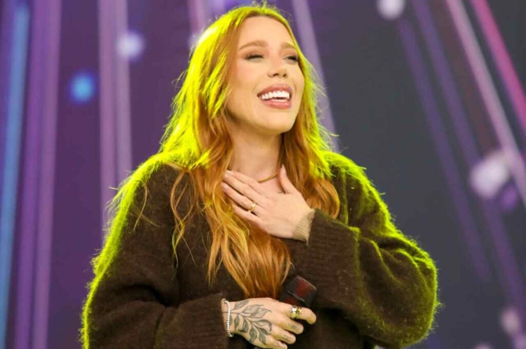 Cantora Julliany Souza sorrindo durante apresentação no palco
