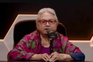 Irmã Ereni Miranda participa de entrevista em estúdio de podcast, falando ao microfone durante gravação.