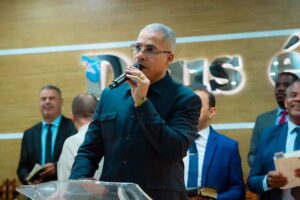 Pastor Júnior Trovão prega ao microfone diante de uma congregação.