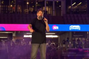 Pastor Tassos Lycurgo canta ao microfone durante apresentação em evento