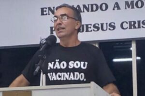 Pastor aparece pregando ao lado de um púlpito com camiseta com a frase “Não sou vacinado”.