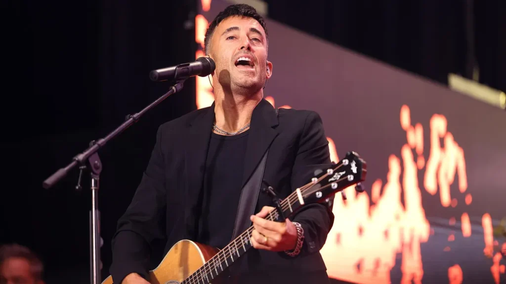 Phil Wickham cantando e tocando violão durante apresentação