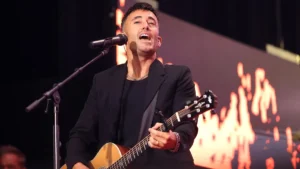 Phil Wickham cantando e tocando violão durante apresentação