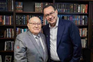 Augusto Cury e José Wellington aparecem juntos em frente a uma estante de livros