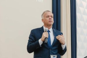 Homem de terno azul participa de evento gospel e fala ao público