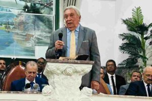 Pastor Gilvan Rodrigues prega em igreja diante de um púlpito
