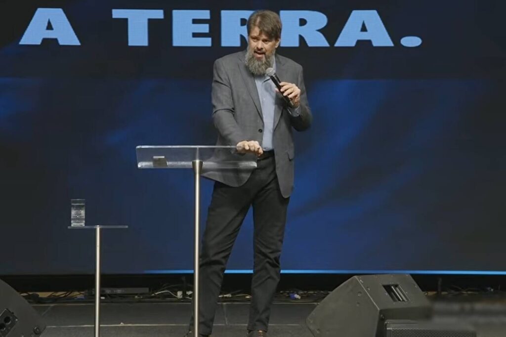 Pastor Tassos Lycurgo prega durante evento religioso em palco