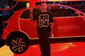 Yude Tamashiro posa ao lado de carro durante evento