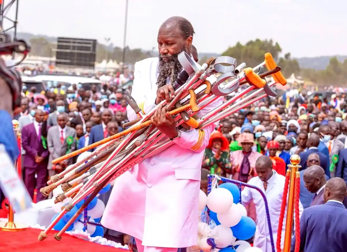 David Owuor segura várias muletas diante de uma multidão durante evento religioso no Quênia