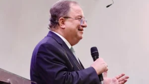 Reverendo Arival Dias Casimiro durante pregação, segurando um microfone