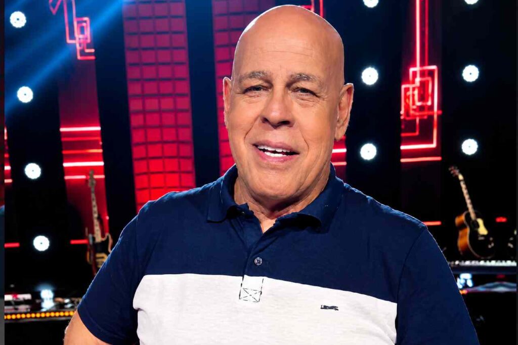 Cantor gospel Mattos Nascimento aparece sorrindo durante participação em programa de televisão, usando camisa polo azul-marinho e branca.